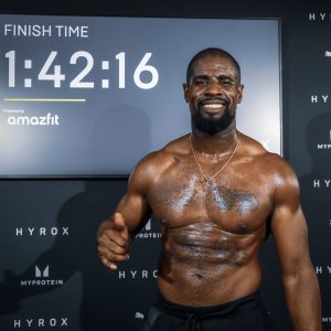DFWS personal trainer glimlacht na voltooiing van Hyrox-evenement met tijdweergave